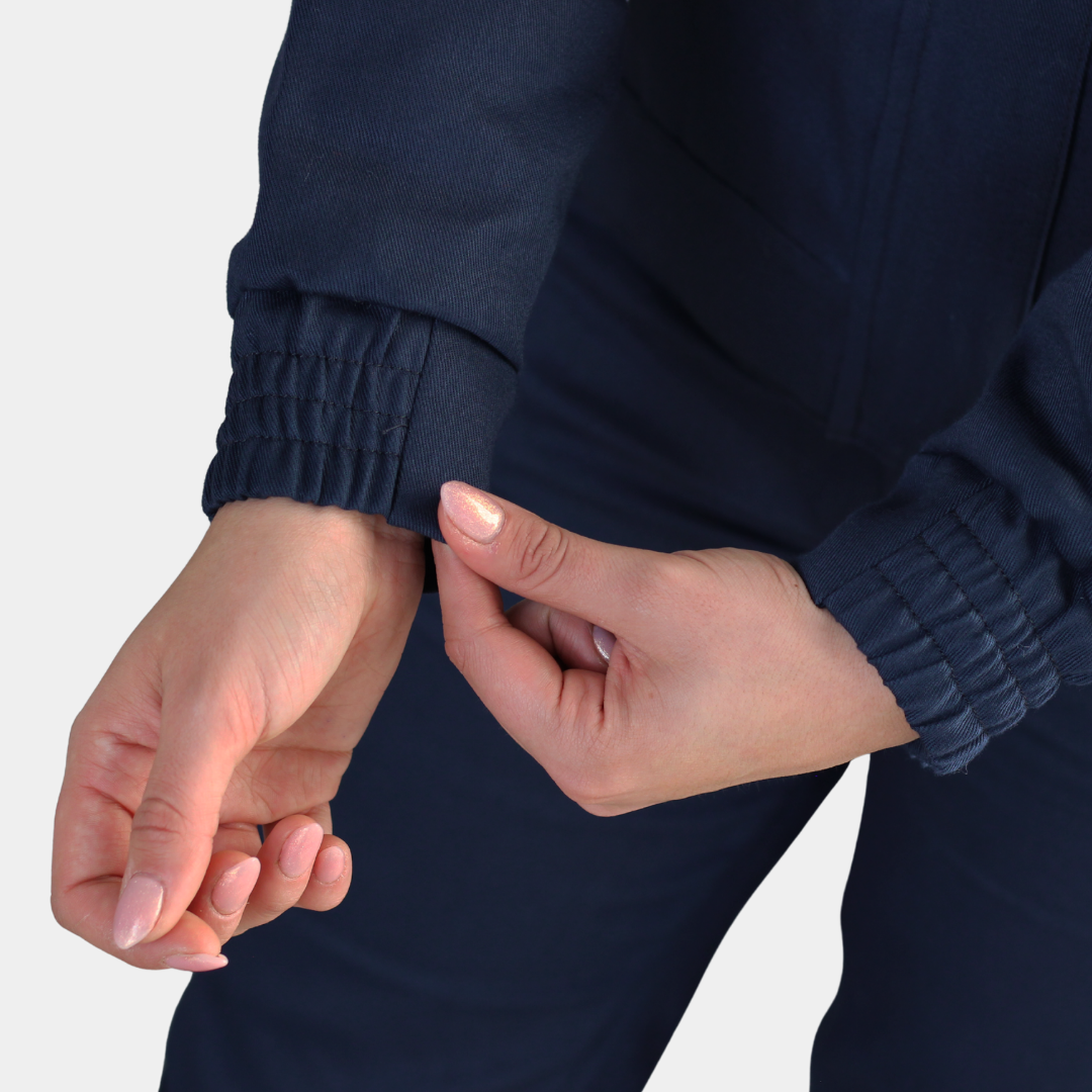 Detalle de puño ajustable de chaqueta ignífuga FIREWEAR® bicolor azul y naranjo para mujer.