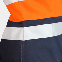 Detalle de cinta reflectante de blusa ignífuga FIREWEAR® bicolor naranjo y azul para mujer.