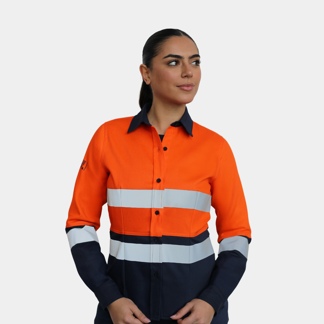 Mujer usando blusa ignífuga FIREWEAR® bicolor naranjo y azul en vista frontal.