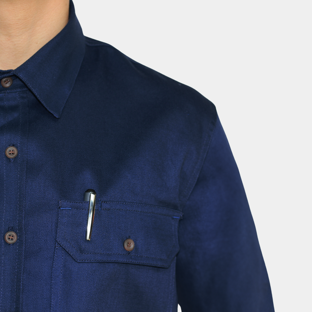Detalle de bolsillo de pecho de camisa ignífuga FIREWEAR® azul marino para hombre.
