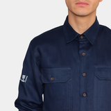 Detalle de bolsillos de pecho de camisa ignífuga FIREWEAR® azul marino para hombre.
