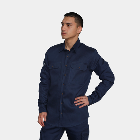 Hombre usando camisa ignífuga FIREWEAR® azul marino en vista frontal con mano en la cintura.