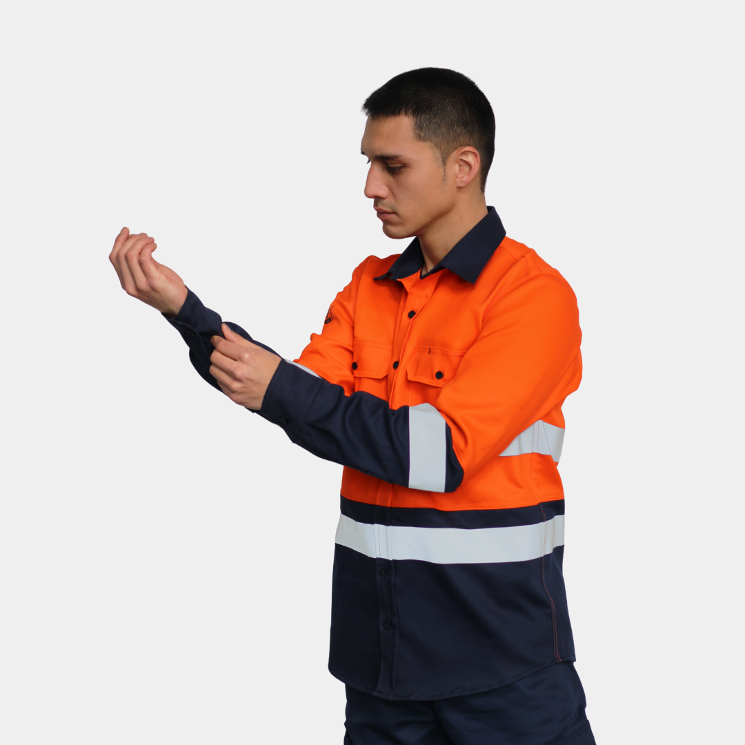 Detalle de puño de camisa ignífuga FIREWEAR® bicolor naranjo y azul para hombre.