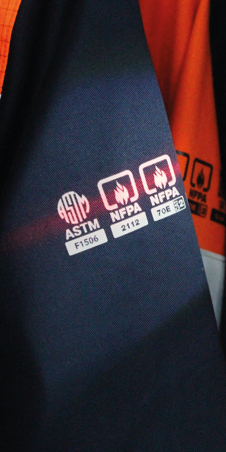 Detalle de certificación y etiquetado técnico en ropa ignífuga FIREWEAR® VITATEX.