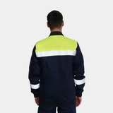 Hombre usando chaqueta ignífuga FIREWEAR® bicolor azul y amarillo en vista posterior.