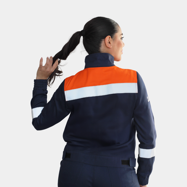 Mujer usando chaqueta ignífuga FIREWEAR® bicolor azul y naranjo en vista posterior.