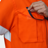 Detalle de bolsillo de pecho de chaqueta ignífuga FIREWEAR® bicolor naranjo y azul para hombre.