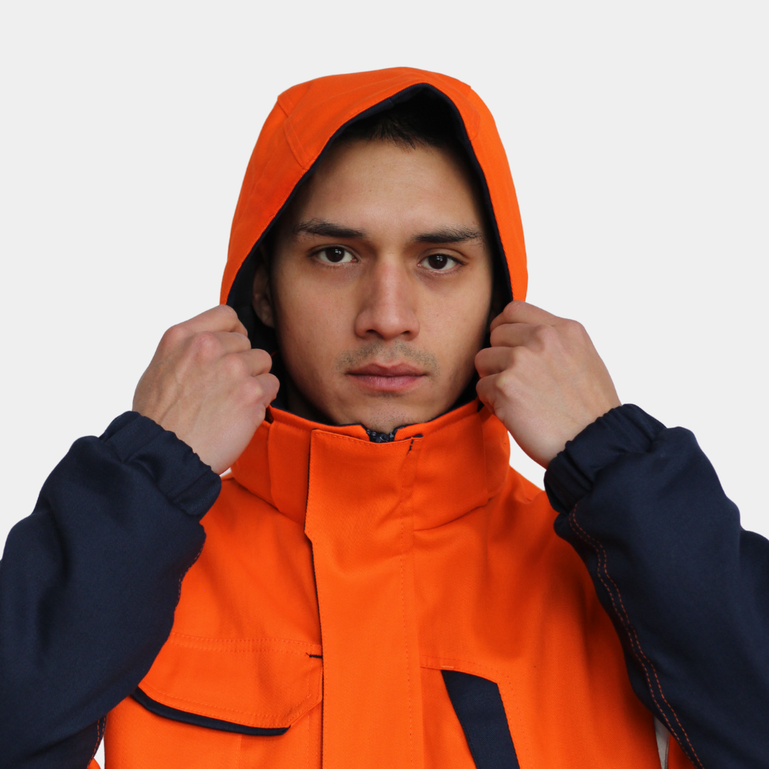 Hombre usando chaqueta térmica ignífuga FIREWEAR® bicolor naranjo y azul en vista frontal con capucha.