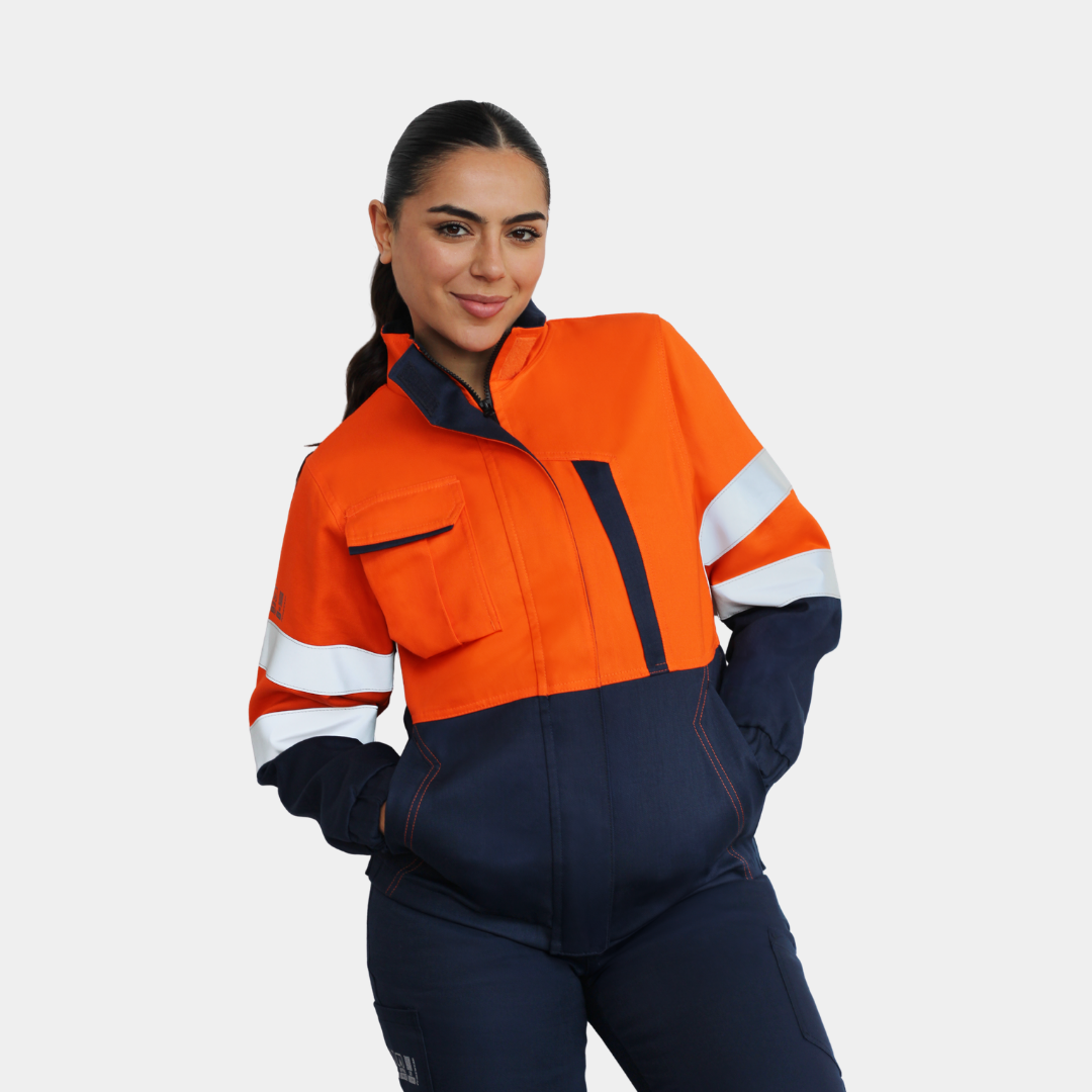 Mujer usando chaqueta térmica ignífuga FIREWEAR® bicolor naranjo y azul en vista tres cuartos.