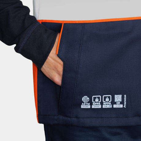 Detalle de bolsillo de pecho de geólogo ignífugo FIREWEAR® bicolor naranjo y azul para hombre.