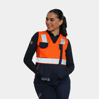 Mujer usando geólogo ignífugo FIREWEAR® bicolor naranjo y azul R201-2 con manos en los bolsillos.