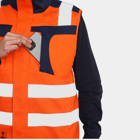 Detalle de bolsillo de pecho de geólogo ignífugo FIREWEAR® naranjo y azul para hombre.