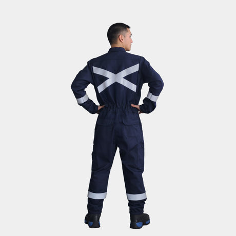 Hombre usando overol ignífugo FIREWEAR® azul marino en vista posterior de cuerpo completo.