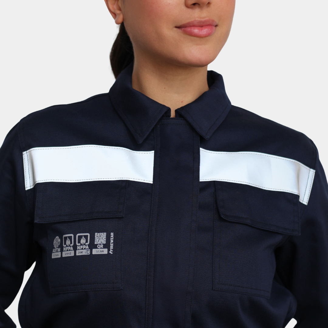Detalle de pecho y cintas reflectantes de overol ignífugo FIREWEAR® azul marino para mujer.