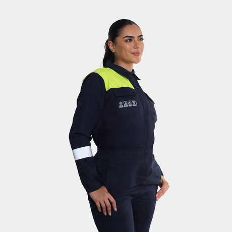 Mujer usando overol ignífugo FIREWEAR® bicolor azul y amarillo en vista tres cuartos izquierda.