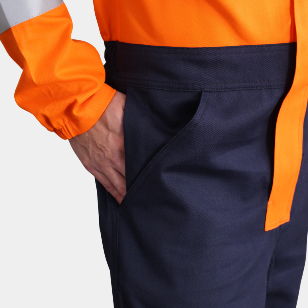 Detalle de bolsillo lateral de overol ignífugo FIREWEAR® bicolor naranjo y azul para hombre.
