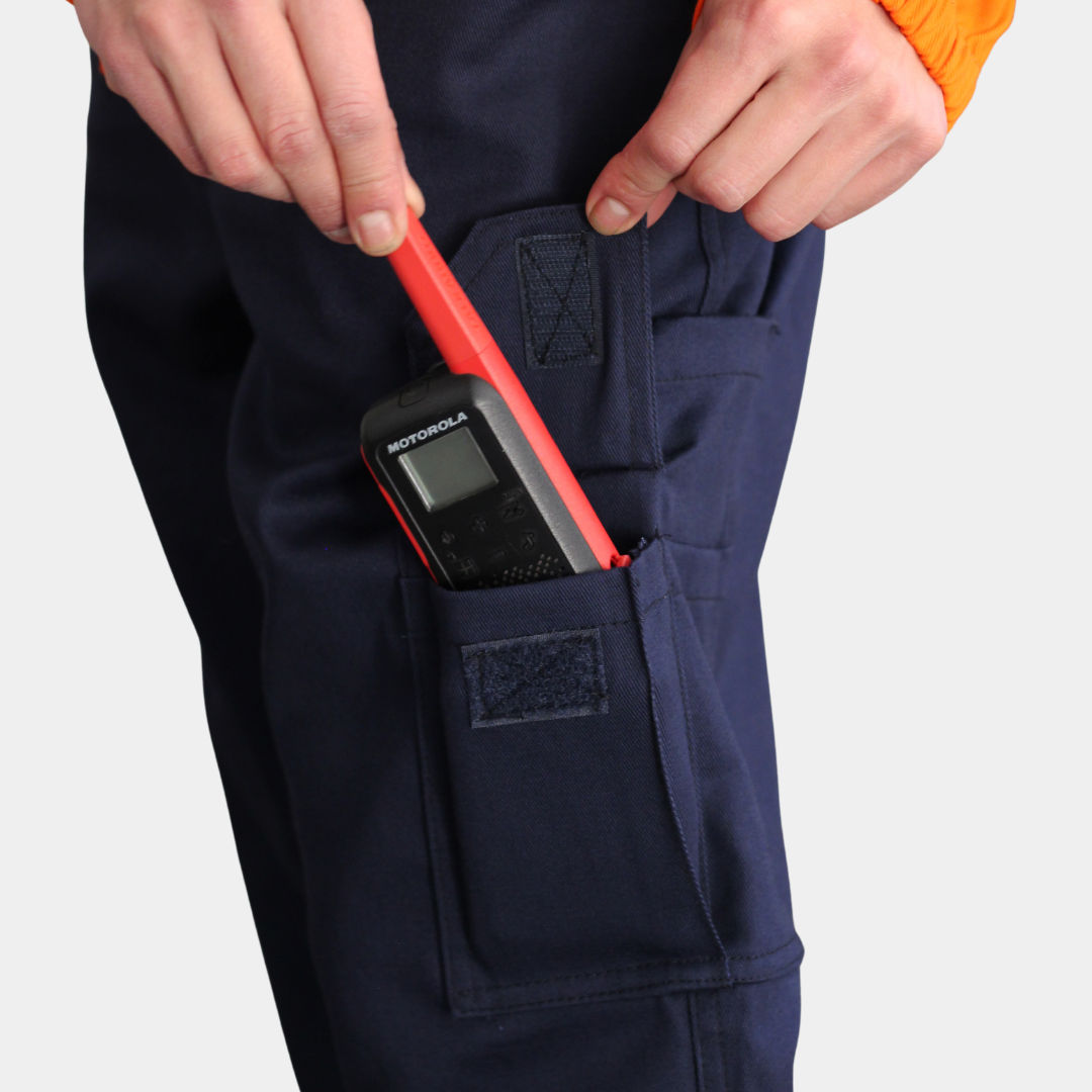 Detalle de bolsillo para radio de overol ignífugo FIREWEAR® bicolor naranjo y azul para hombre.