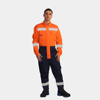 Hombre usando overol ignífugo FIREWEAR® bicolor naranjo y azul en vista frontal de cuerpo completo.