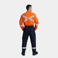 Hombre usando overol ignífugo FIREWEAR® bicolor naranjo y azul en vista posterior.