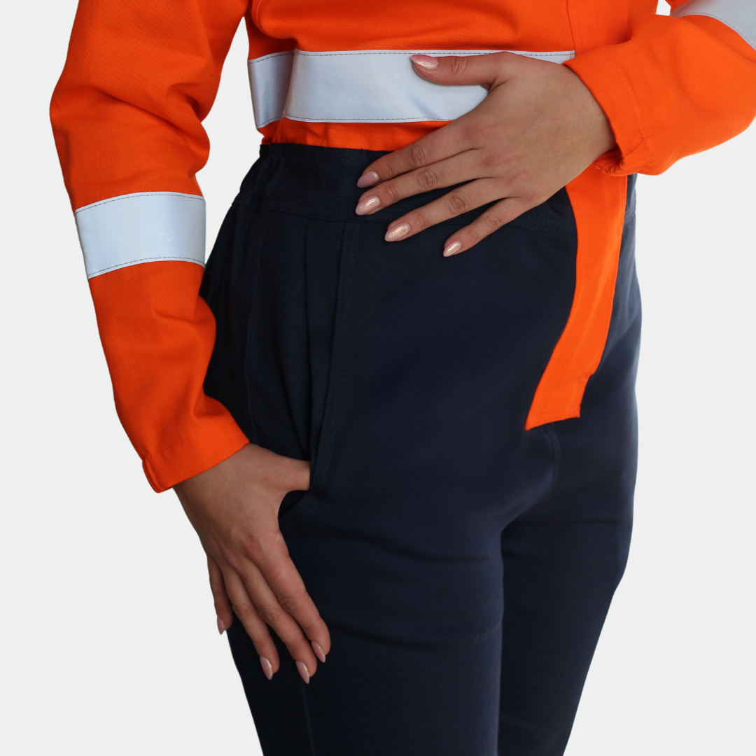 Detalle de bolsillo de cadera de overol ignífugo FIREWEAR® bicolor naranjo y azul para mujer.