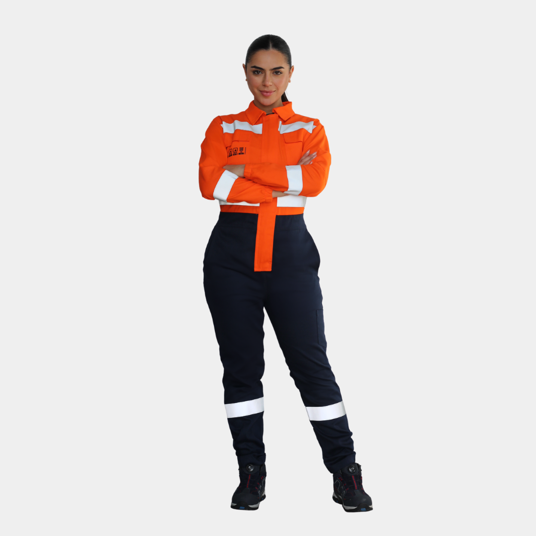 Mujer usando overol ignífugo FIREWEAR® bicolor naranjo y azul en vista frontal de cuerpo completo.