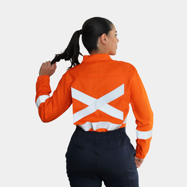 Mujer usando overol ignífugo FIREWEAR® bicolor naranjo y azul en vista posterior.