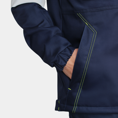 Detalle de bolsillo lateral de parka ignífuga impermeable FIREWEAR® bicolor azul y amarillo para hombre.