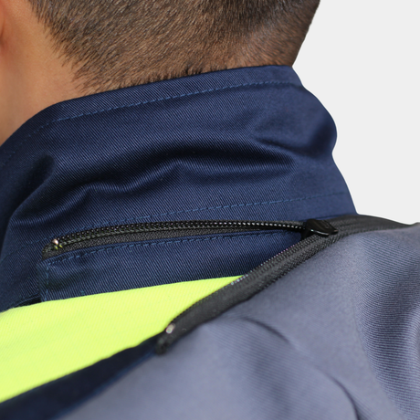 Detalle de cuello y hombro de parka ignífuga impermeable FIREWEAR® bicolor azul y amarillo para hombre.
