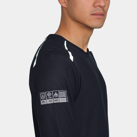 Detalle de manga de polera ignífuga FIREWEAR® azul marino de cuello redondo para hombre.
