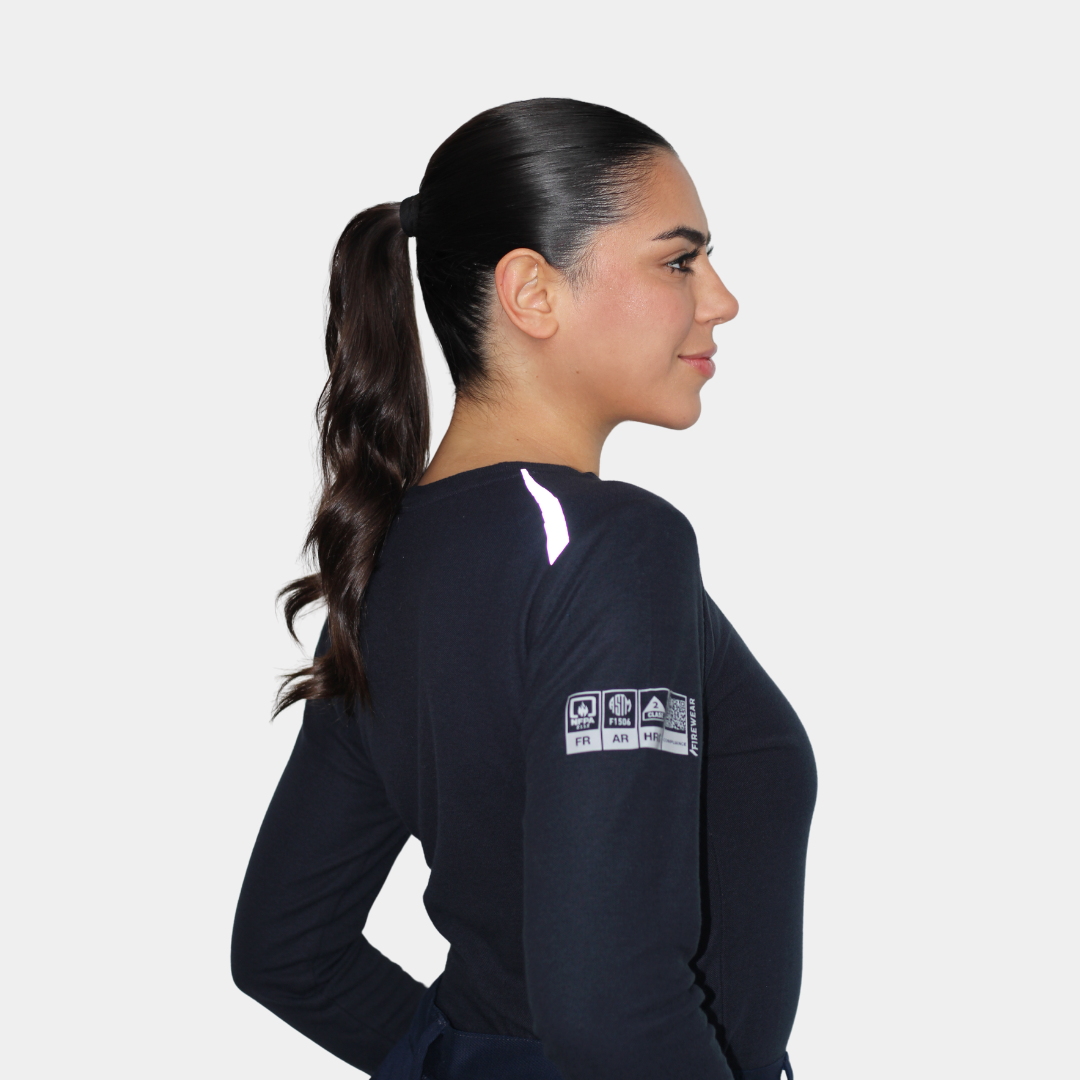 Mujer usando polera ignífuga FIREWEAR® azul marino de cuello redondo en vista lateral.