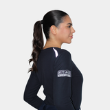 Mujer usando polera ignífuga FIREWEAR® azul marino de cuello redondo en vista lateral.