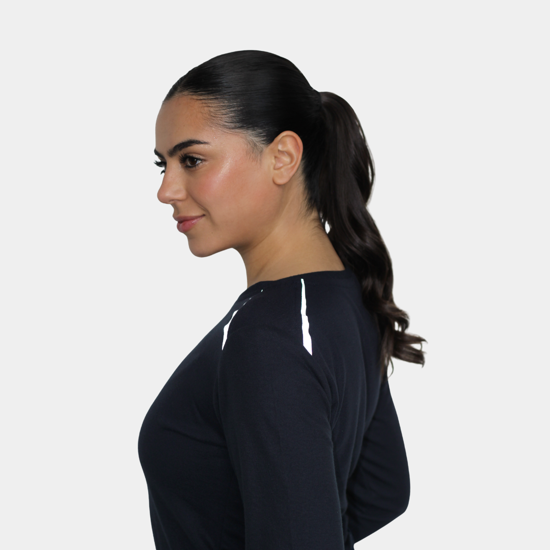 Mujer usando polera ignífuga FIREWEAR® azul marino de cuello redondo en vista posterior tres cuartos.
