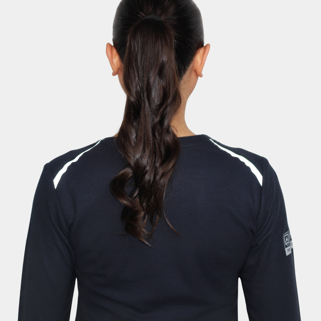 Mujer usando polera ignífuga FIREWEAR® azul marino de cuello redondo en vista posterior.