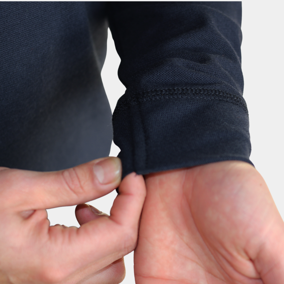 Detalle de puño y manga de polera polo ignífuga FIREWEAR® azul marino para hombre.