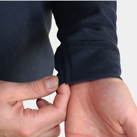 Detalle de puño y manga de polera polo ignífuga FIREWEAR® azul marino para hombre.