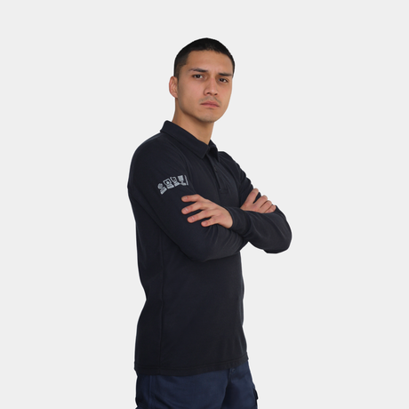 Hombre usando polera polo ignífuga FIREWEAR® azul marino en vista frontal con brazos cruzados.