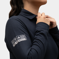 Detalle de manga y tejido de polera polo ignífuga FIREWEAR® azul marino para mujer.