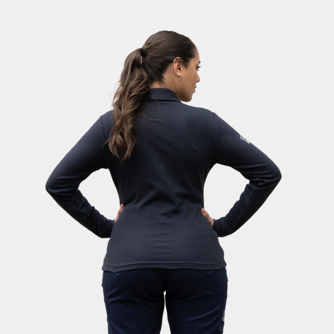 Mujer usando polera polo ignífuga FIREWEAR® azul marino en vista posterior.