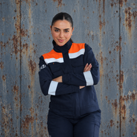 Mujer usando chaqueta ignífuga FIREWEAR® azul marino y naranja de VITATEX con cintas reflectantes.